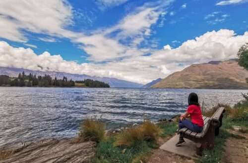 Sitting on a bench by Lake Wakatipu, New Zealand - RooWanders